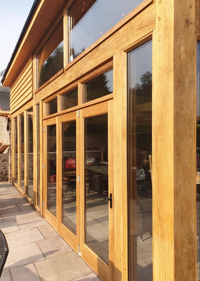 A bespoke oak garden room by Crickhowell Joinery, glazing set into stone under the Usk valley hills